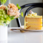 Plated slice of vanilla cake wiht lemon filling and lemon butter cream